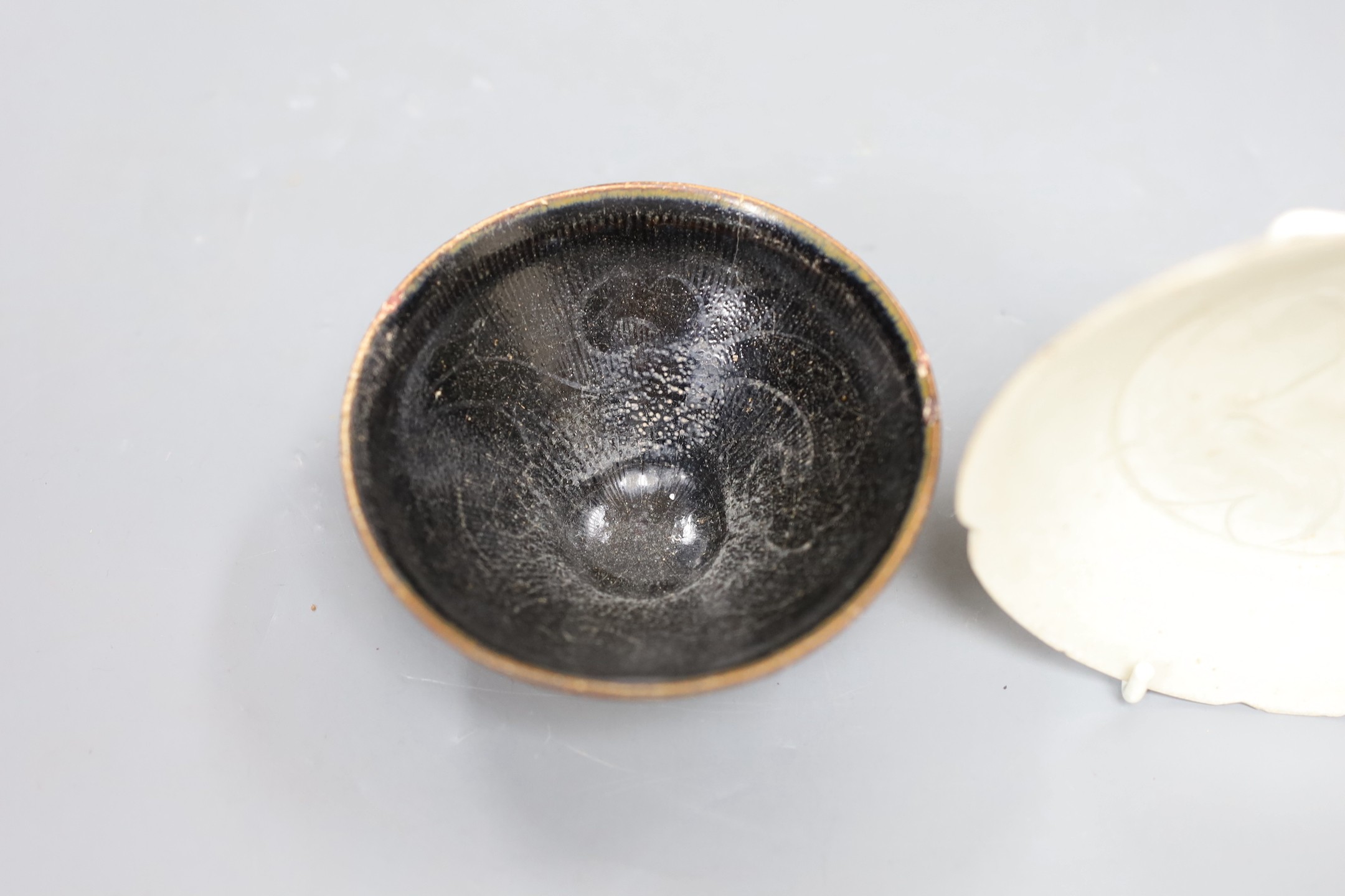 A Chinese Jizhou ‘scrolling leaf’ bowl, Song Dynasty, 11cm and a carved qingbai dish, 14cm